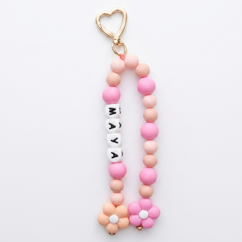 Pink and gold keychain with beads and a heart-shaped keyring on a white background