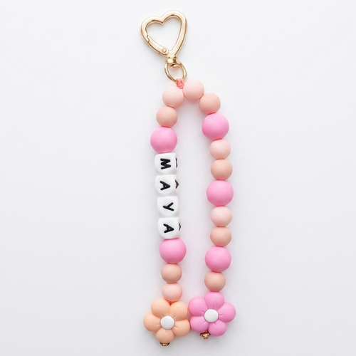 Pink and gold keychain with beads and a heart-shaped keyring on a white background