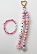 Beaded keychain and bracelet set with heart and flower charms on a white background